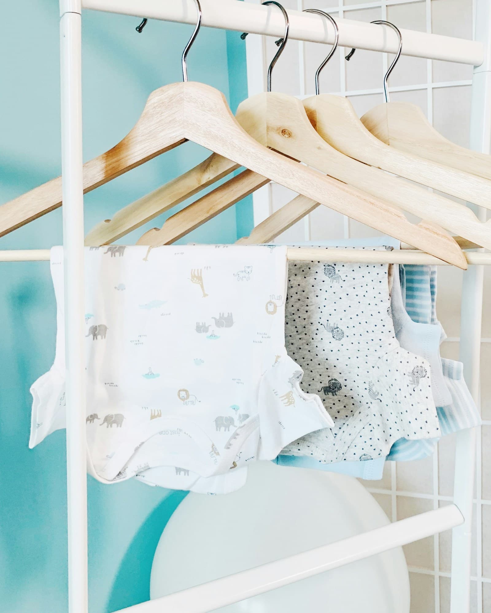 Trois bodies de bébé de couleurs différentes, posés côte à côte.