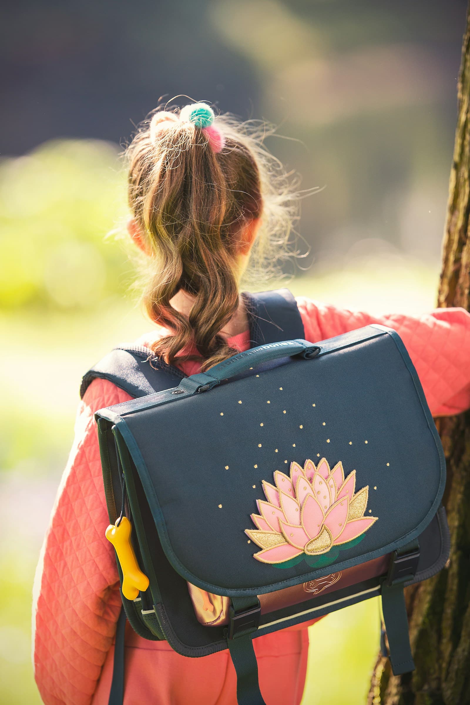 Une fille debout, son sac à dos sur les épaules.