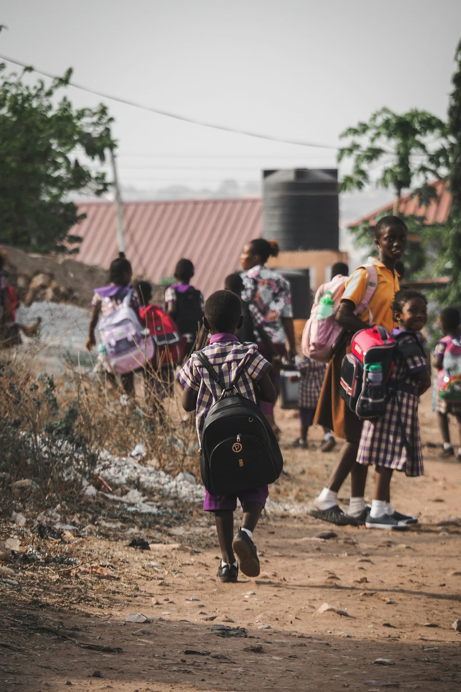 Des enfants rentrent de l'école, leur sac sur le dos.