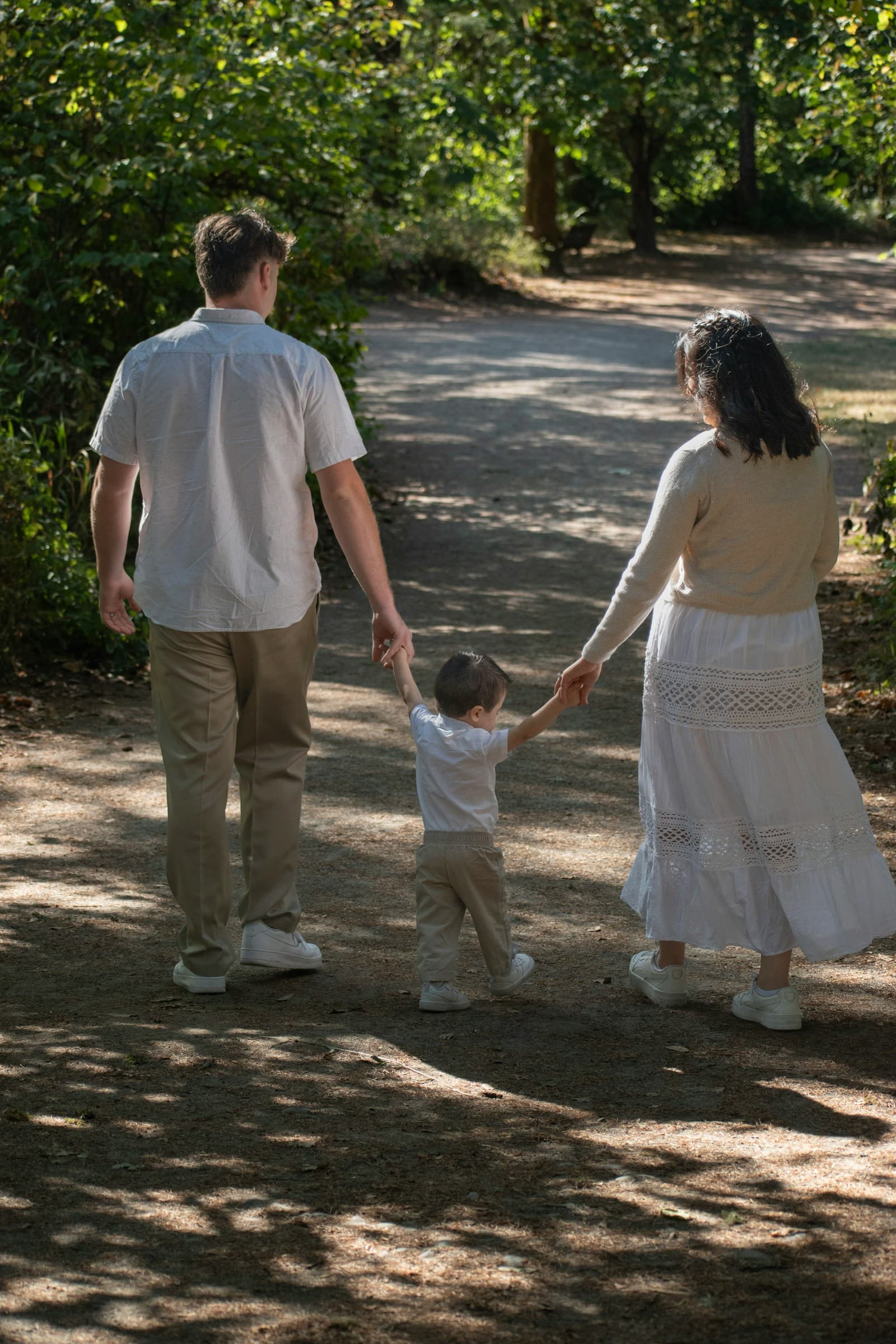 Une famille marche sur un sentier bordé d'arbres.